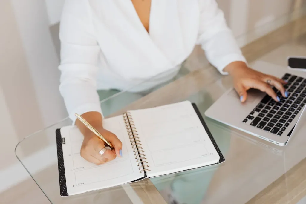 Mulher montando um cronograma de postagem no caderno