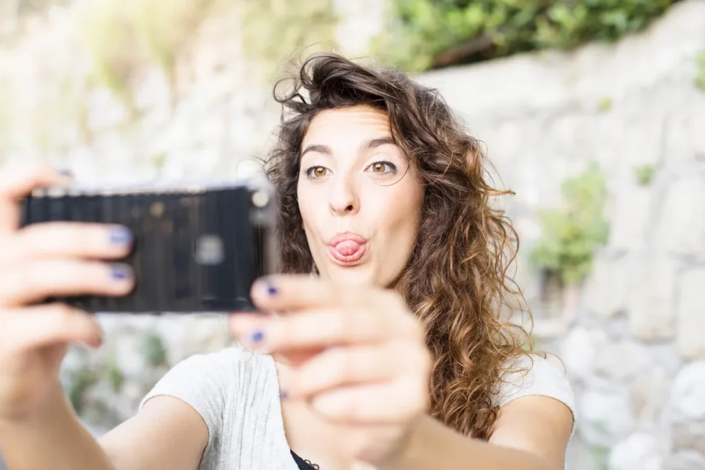 Mulher fazendo careta e tirando selfie