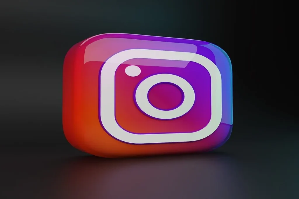O ícone 3D e brilhante do Instagram, com seu gradiente de cores que vai do vermelho ao roxo, sobre um fundo escuro.