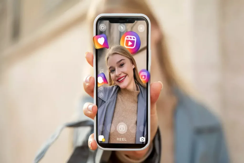 Uma pessoa segurando um smartphone com a interface do Instagram Reels, mostrando uma mulher sorrindo e ícones 3D das redes sociais, simbolizando a criação de conteúdo com o tom de voz da marca.