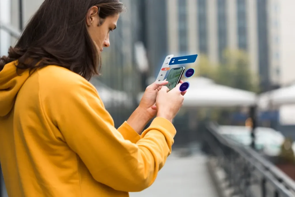 Homem usando smartphone com interface digital em realidade aumentada, representando tecnologia, aplicativos e inovação digital.