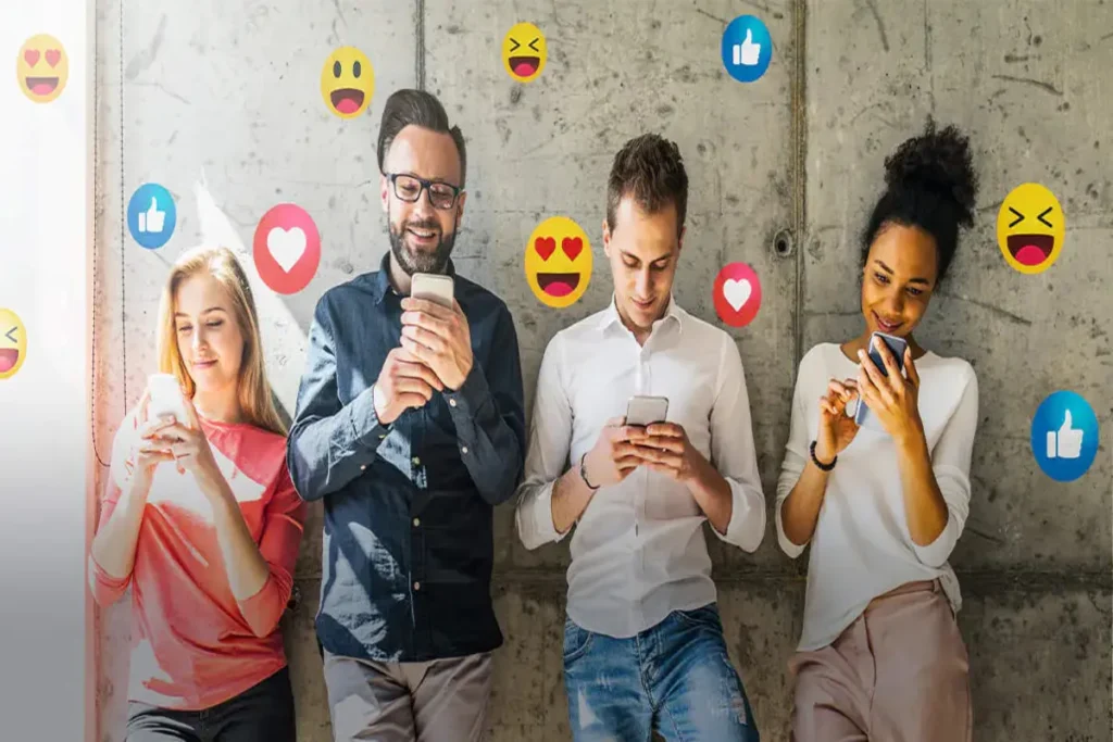 Pessoas de diferentes idades e etnias sorrindo e usando seus celulares. Ícones de engajamento de mídias sociais como corações e emojis flutuam ao redor delas.